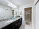 Bathroom with granite countertops, double sinks, and a walk-in shower at 8931 Sydney Ave, Kissimmee, FL 34747