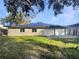 Rear view of house featuring solar panels and a spacious yard at 706 Tournament Ln, Kissimmee, FL 34759