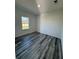 Simple bedroom with grey vinyl plank flooring and a window at 6208 Sw 129, Ocala, FL 34473