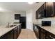 Modern kitchen with granite countertops, dark wood cabinets, and stainless steel appliances at 2036 Van Buren Loop, Auburndale, FL 33823