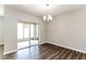 Bright dining room with sliding glass doors leading to a patio, hardwood floors and modern chandelier at 2036 Van Buren Loop, Auburndale, FL 33823