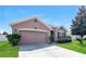 One-story home with a two-car garage, landscaping, and a neutral color palette at 2036 Van Buren Loop, Auburndale, FL 33823