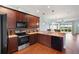 Kitchen with dark wood cabinets, stainless steel appliances, and granite countertops at 22011 Belgian Ct, Mount Dora, FL 32757
