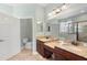 Double vanity bathroom with granite countertop and large mirror at 22011 Belgian Ct, Mount Dora, FL 32757