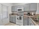 Kitchen with gray cabinets, white appliances, and double sink at 1029 Park Ridge Cir, Kissimmee, FL 34746
