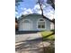 Charming light blue house with a white garage door and manicured lawn at 6910 Kelcher Ct, Orlando, FL 32807