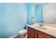 Clean bathroom with light blue walls, wood vanity, and updated toilet at 600 Via Chris Ct, Debary, FL 32713