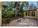 Brick paved patio with two stone benches and potted plants at 600 Via Chris Ct, Debary, FL 32713