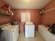 Laundry room with washer, dryer, and storage shelving at 5937 Colchester Dr, Orlando, FL 32812