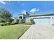 Two-story home with gray siding, paver driveway, and landscaped lawn at 4813 Terra Sole Place, St Cloud, FL 34771