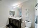 Modern bathroom with dark vanity, toilet and large mirror at 4813 Terra Sole Place, St Cloud, FL 34771