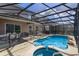 Inviting pool area with screened enclosure, spa, and patio furniture at 5295 Wildwood Way, Davenport, FL 33837