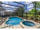 Screened pool and spa with surrounding landscaping at 5295 Wildwood Way, Davenport, FL 33837