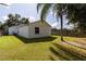 View of home's exterior and backyard with grassy lawn and palm tree at 5631 La Joya Ct, Orlando, FL 32808