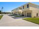 Row of tan townhomes with double garages and landscaping at 164 Holly Village Dr, Davenport, FL 33837