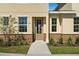 Front door entrance of a townhome with stone accents and landscaping at 164 Holly Village Dr, Davenport, FL 33837