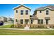 Two story townhome with tan siding, stone accents, and landscaping at 164 Holly Village Dr, Davenport, FL 33837