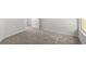 Empty bedroom with gray carpeting, neutral walls, and an open doorway at 164 Holly Village Dr, Davenport, FL 33837