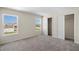 Spacious bedroom with gray carpet, two windows, and a double-door closet at 164 Holly Village Dr, Davenport, FL 33837