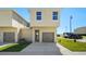 Tan two-story townhome with a double-car garage at 164 Holly Village Dr, Davenport, FL 33837