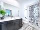 Modern bathroom with dark vanity, white quartz countertop, and large mirror at 128 Hampton Loop, Davenport, FL 33837