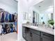 Elegant bathroom with dark vanity, walk-in closet, and modern fixtures at 128 Hampton Loop, Davenport, FL 33837