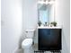 Modern bathroom with dark vanity, white toilet and stylish decor at 128 Hampton Loop, Davenport, FL 33837