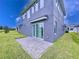 Gray house with a backyard patio and grassy area at 128 Hampton Loop, Davenport, FL 33837
