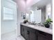 Contemporary bathroom with dark vanity, large mirror, and grey tile flooring at 128 Hampton Loop, Davenport, FL 33837