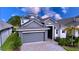 Two story house with gray exterior and paver driveway at 128 Hampton Loop, Davenport, FL 33837