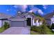 Two-story house with gray exterior and gray paver driveway at 128 Hampton Loop, Davenport, FL 33837