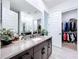 Elegant bathroom with double sinks and access to a large closet at 128 Hampton Loop, Davenport, FL 33837