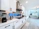 Modern kitchen with white cabinets, stainless steel appliances, and a breakfast bar at 128 Hampton Loop, Davenport, FL 33837