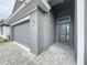 Modern home exterior, gray garage door and front entry at 128 Hampton Loop, Davenport, FL 33837