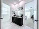 Modern bathroom with dark vanity and view into bedroom at 128 Hampton Loop, Davenport, FL 33837