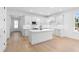 Modern white kitchen with an island, stainless steel appliances, and light wood floors at 4190 Rossmore Dr, Orlando, FL 32810