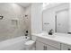 Modern bathroom with gray tile, white vanity, and bathtub at 4190 Rossmore Dr, Orlando, FL 32810