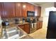 Well-equipped kitchen featuring stainless steel appliances and wood cabinets at 914 Charo Pkwy # 114, Davenport, FL 33897