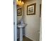 Clean and simple powder room with pedestal sink and framed art at 9033 Rhodes St, Kissimmee, FL 34747