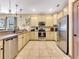 Well-equipped kitchen featuring stainless steel appliances and cream-colored cabinets at 1465 Belle Terre Rd, Davenport, FL 33896