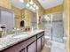Double vanity bathroom with granite countertops and a walk-in shower at 1465 Belle Terre Rd, Davenport, FL 33896