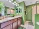 Double vanity bathroom with granite countertops and green walls at 1465 Belle Terre Rd, Davenport, FL 33896