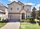 Two story home with beige exterior, stone accents, and landscaping at 1465 Belle Terre Rd, Davenport, FL 33896