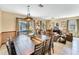 Open concept dining room with large wooden table, view of pool and living area at 1465 Belle Terre Rd, Davenport, FL 33896
