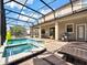 Screened pool, spa, grill, and lounge chairs in backyard at 1465 Belle Terre Rd, Davenport, FL 33896