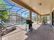 Screened pool area with patio furniture and a grill at 1465 Belle Terre Rd, Davenport, FL 33896