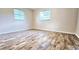 Spacious bedroom with wood-look flooring and ample natural light from two windows at 3220 Chariot Pl, Orlando, FL 32818