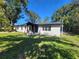 White single-story house with a black roof and wood columns at 899 5Th St, Winter Haven, FL 33881