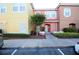 Two-story townhome with yellow and peach exterior, landscaping, and walkway at 904 Park Terrace Cir, Kissimmee, FL 34746