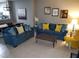 Living room features blue sofas, yellow accent chairs, and a coffee table at 904 Park Terrace Cir, Kissimmee, FL 34746